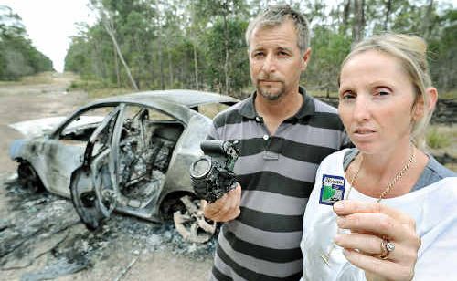 BITTERSWEET: Kim and David Aston with their burnt-out car, destroyed camera and the memory card that miraculously still works. BITTERSWEET: Kim and David Aston with their burnt-out car, destroyed camera and the memory card that miraculously still works.